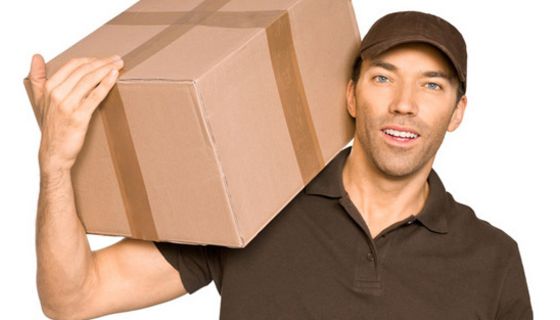 Paketbote trägt Paket auf der Schulter.