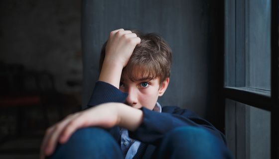 Junge, schaut verzweifelt in die Kamera.