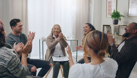 Gruppe von Menschen in einem Stuhlkreis.