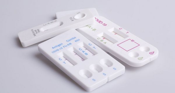 vier Schnelltests für Corona, RSV und Influenza liegen auf einem weißen Untergrund.