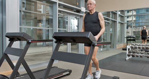 Senior im Fitnessstudio auf dem Laufband