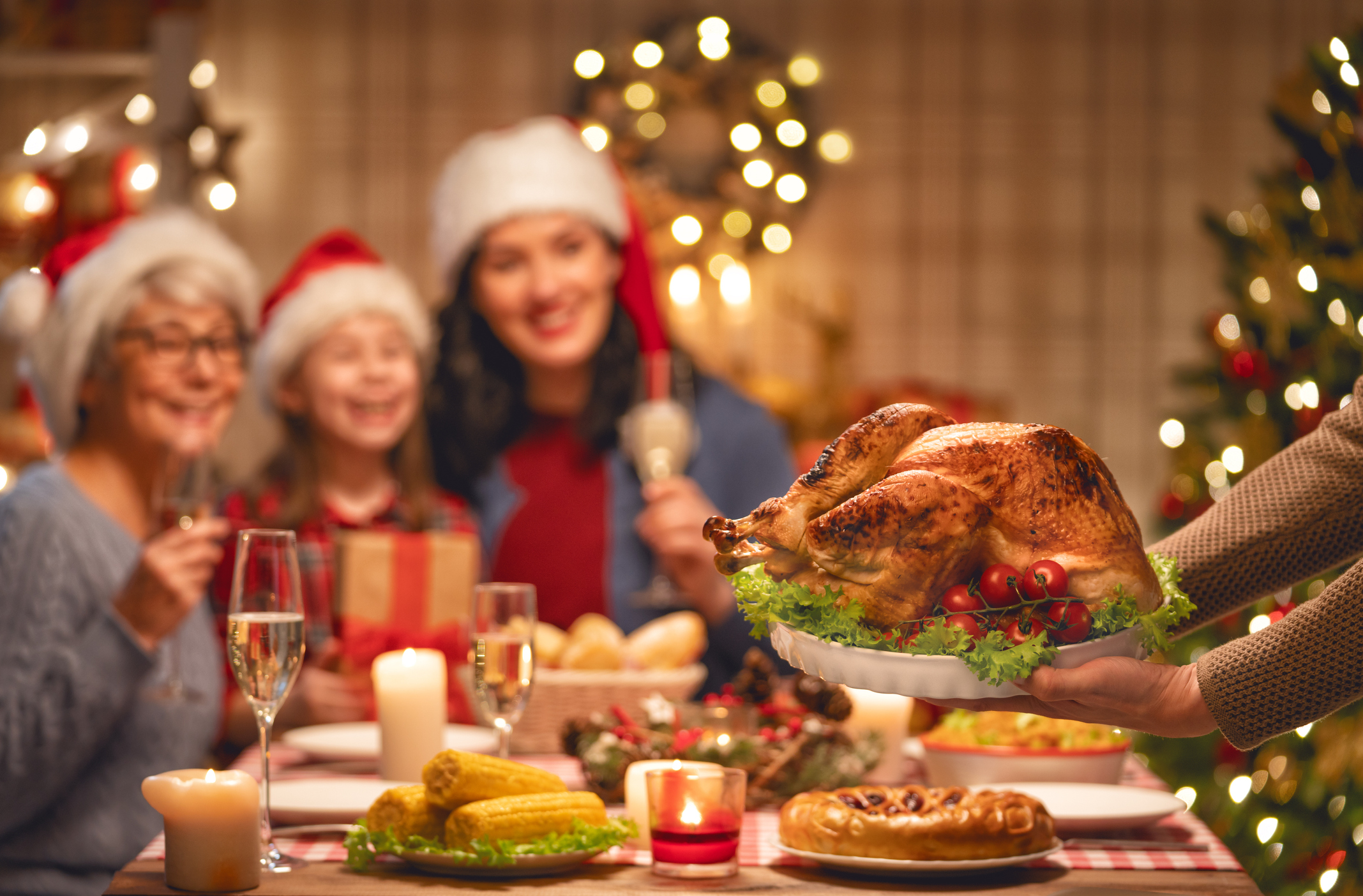 Familie sitzt beim Weihnachtsessen und freut sich auf die Gans.